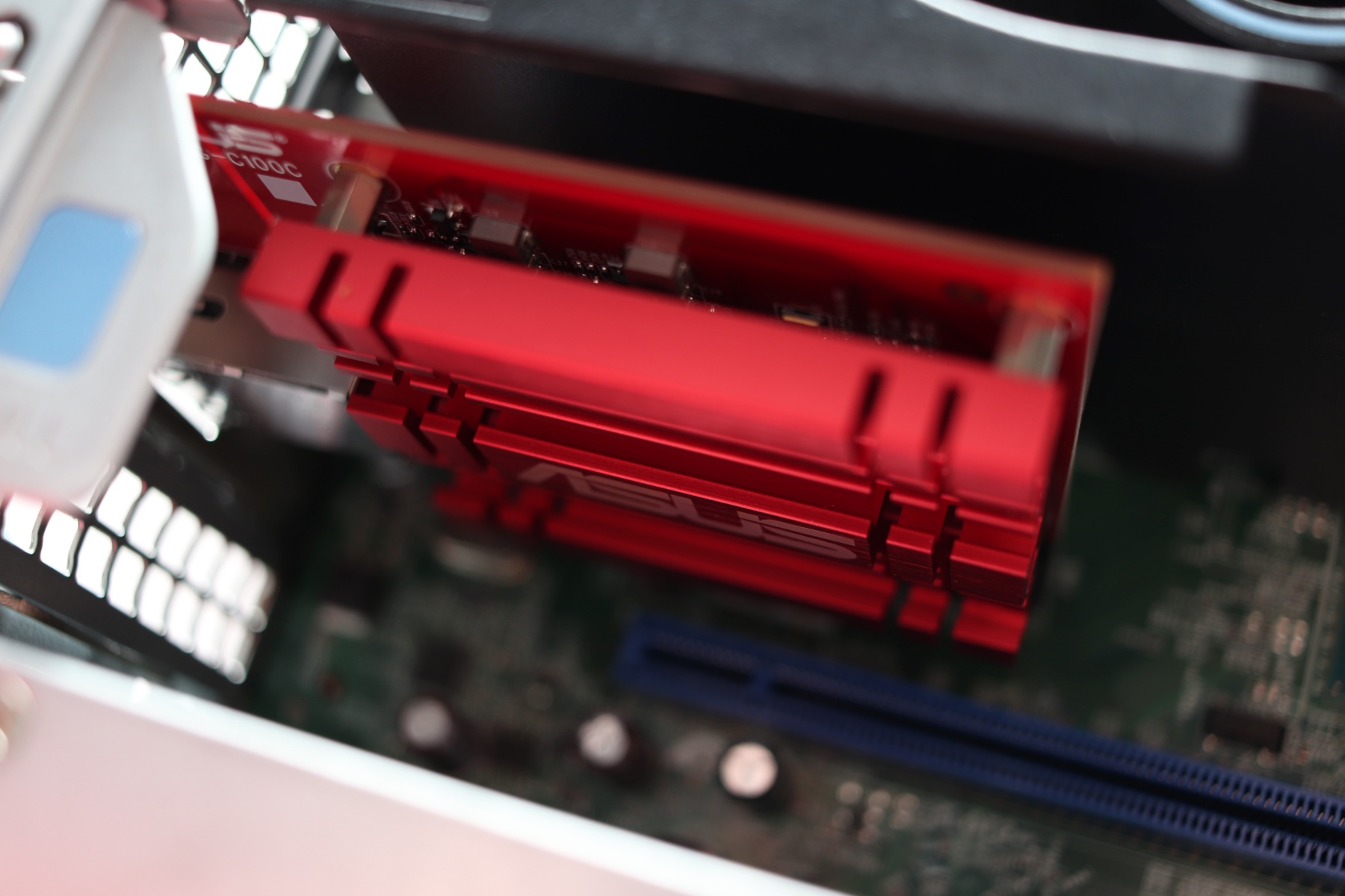 Asus 10 gigabit ethernet card with a red PCB and a red aluminum heatsing, in its PCIe slot.
