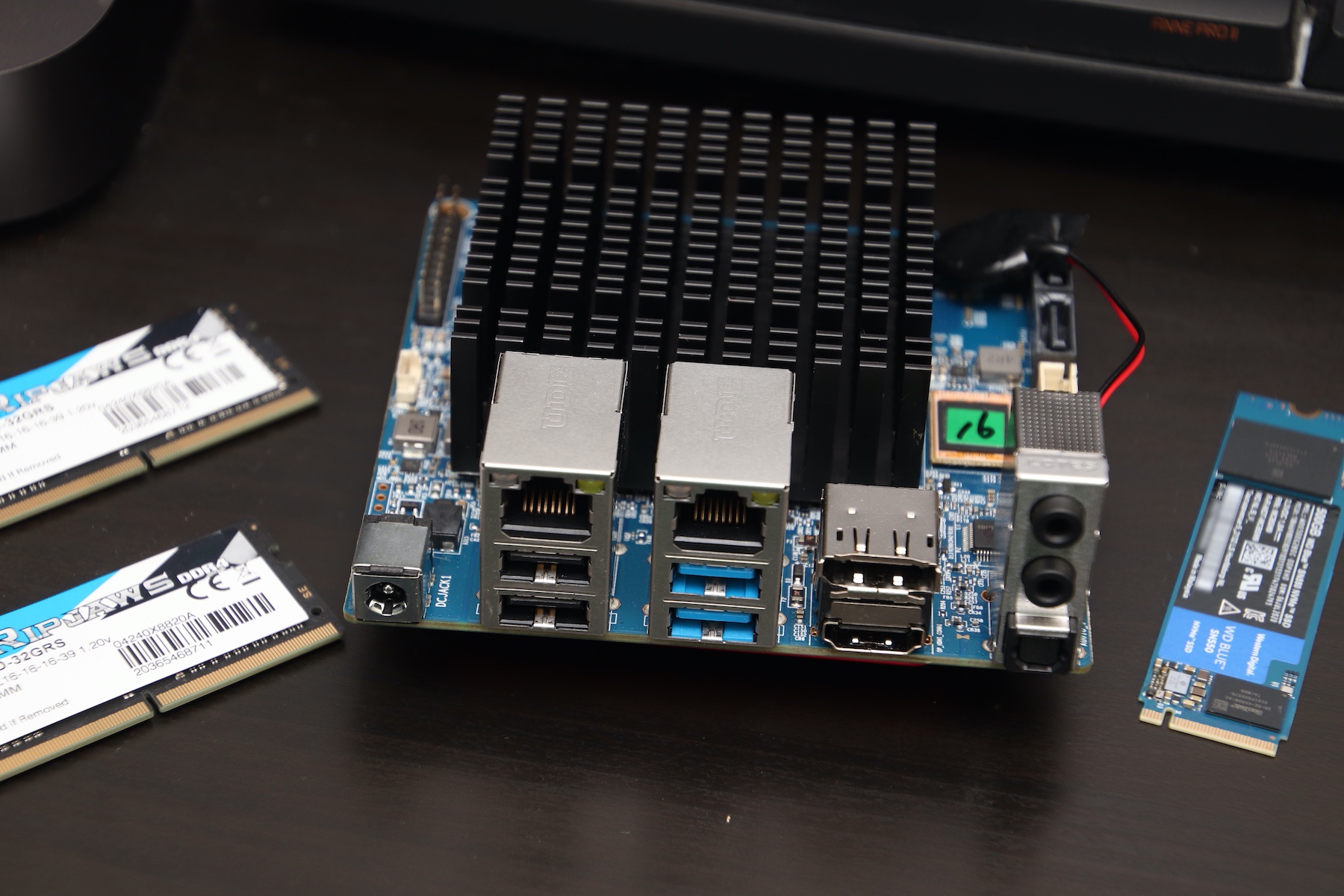 ODROID H2+ from the front, showing all connectivity options: 4 USB ports, HDMI and DisplayPort, 2 RJ45 ports, sound in/out/optical ports, and a barrel jack for power.